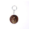 Handcrafted round Gomaya keychain with cow face design and steel ring.